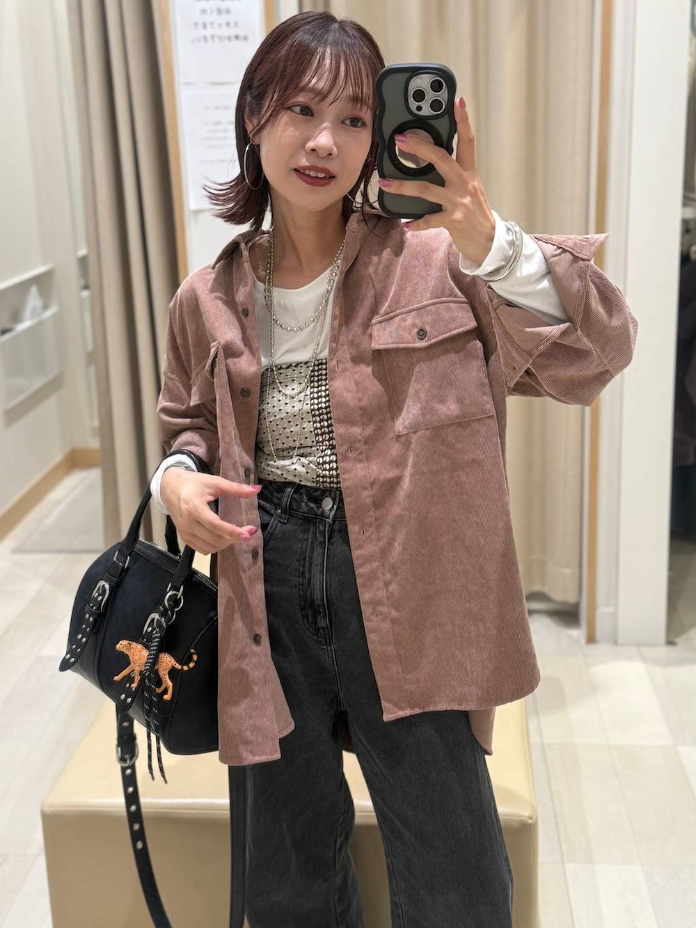 ピンク系のシャツ/ブラウス、ブラック系のボストンバッグ、ブラウン系のベストを着用したレディースの秋コーディネートの2枚目の写真