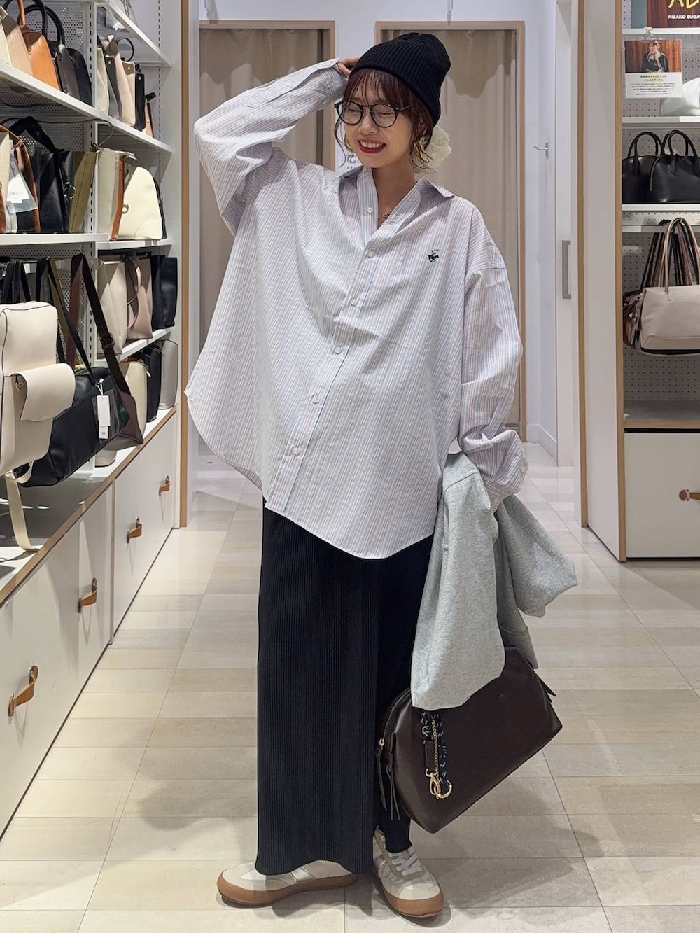 ホワイト系のスニーカー、ブラウン系のボストンバッグ、グレー系のパーカーを着用したレディースの春コーディネートの2枚目の写真