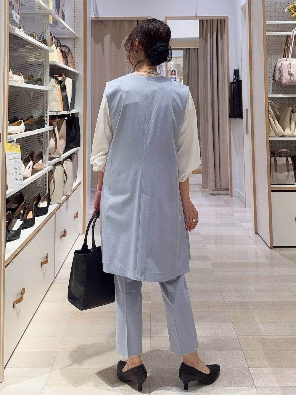 ブラック系のパンプス、ホワイト系のシャツ/ブラウス、ブルー系のスラックスを着用したレディースの冬コーディネートの6枚目の写真