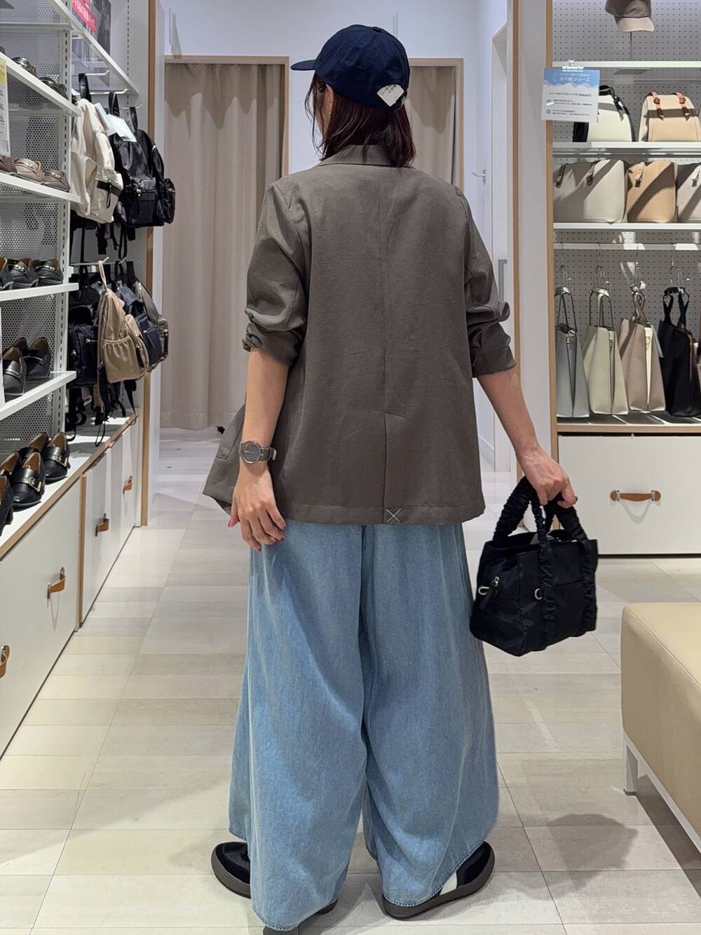 ブラック系のスニーカー、ブラック系のショルダーバッグ、ホワイト系のTシャツ/カットソーを着用したレディースの秋コーディネートの5枚目の写真