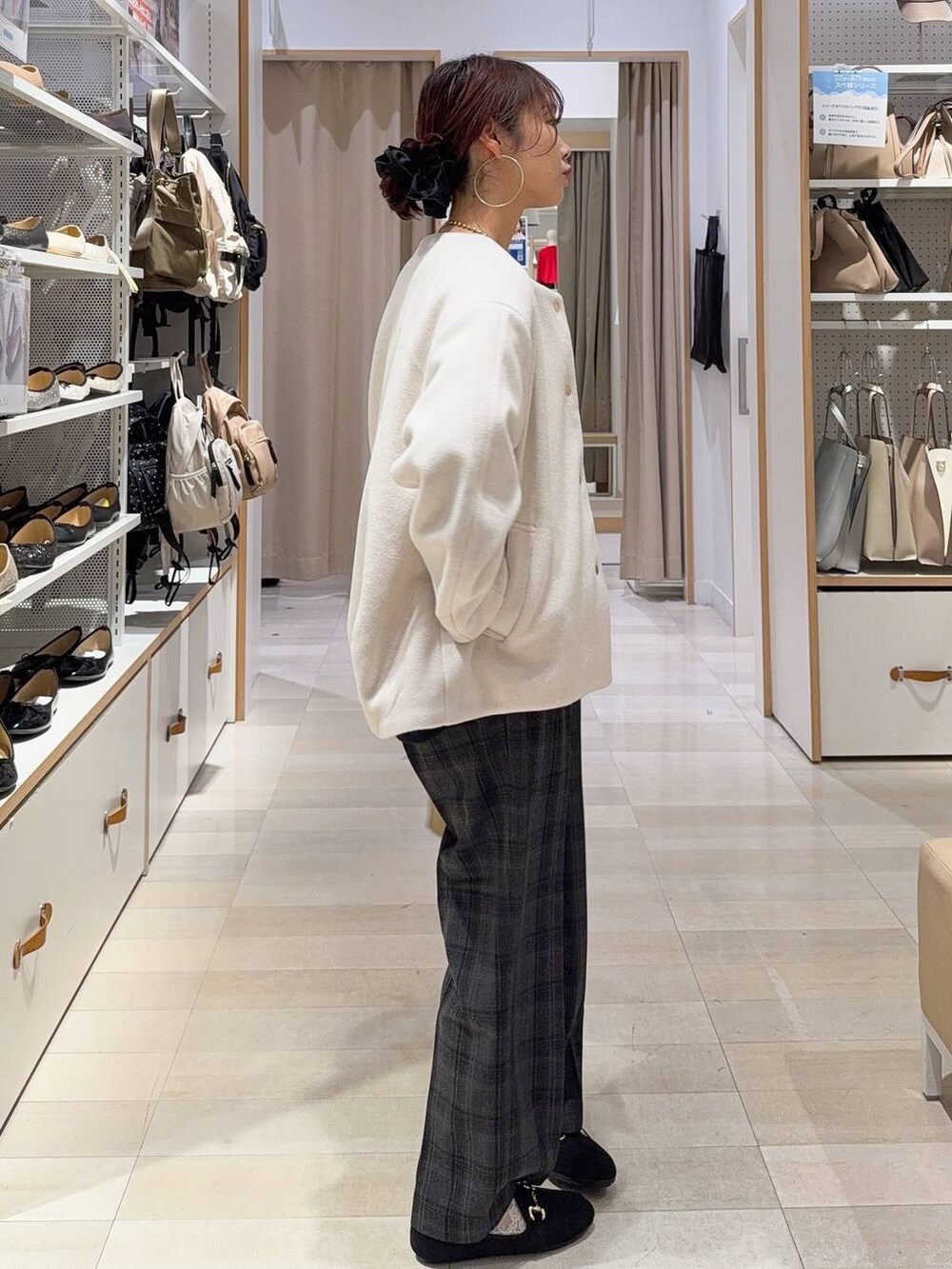 グリーン系のショルダーバッグ、ベージュ系のノーカラーコート、ブラック系のニット/セーターを着用したレディースの秋コーディネートの5枚目の写真