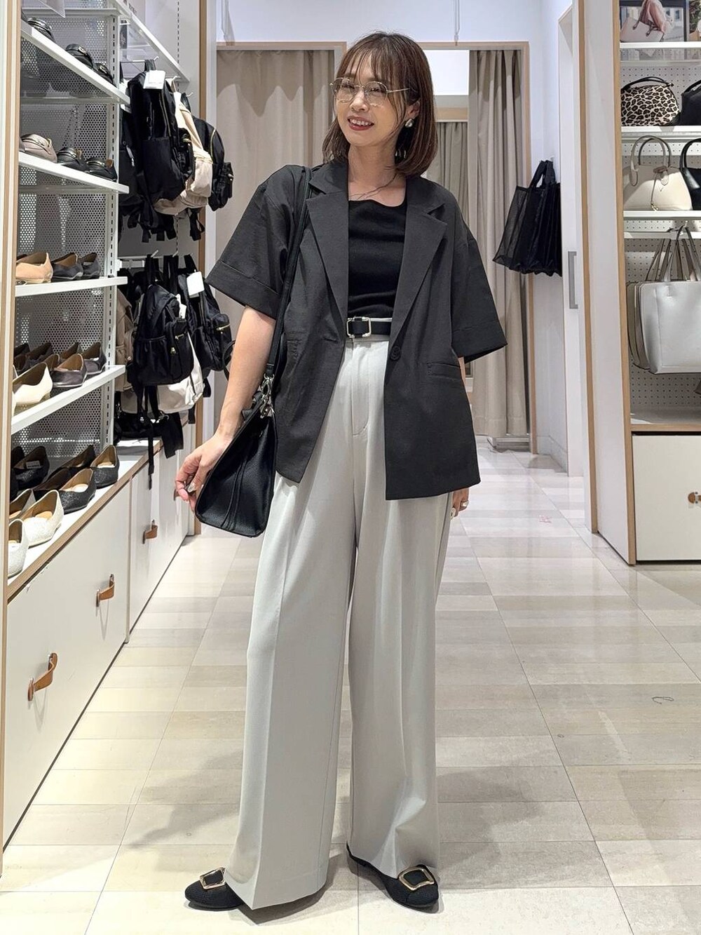 ブラック系のトートバッグ、ブラック系のパンプス、グレー系のその他パンツを着用したレディースの夏コーディネートの5枚目の写真