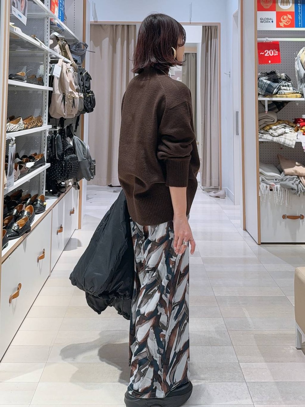 ブラック系のショルダーバッグ、ブラック系のダウンジャケット/コート、ブラック系のブーツを着用したレディースの冬コーディネートの7枚目の写真