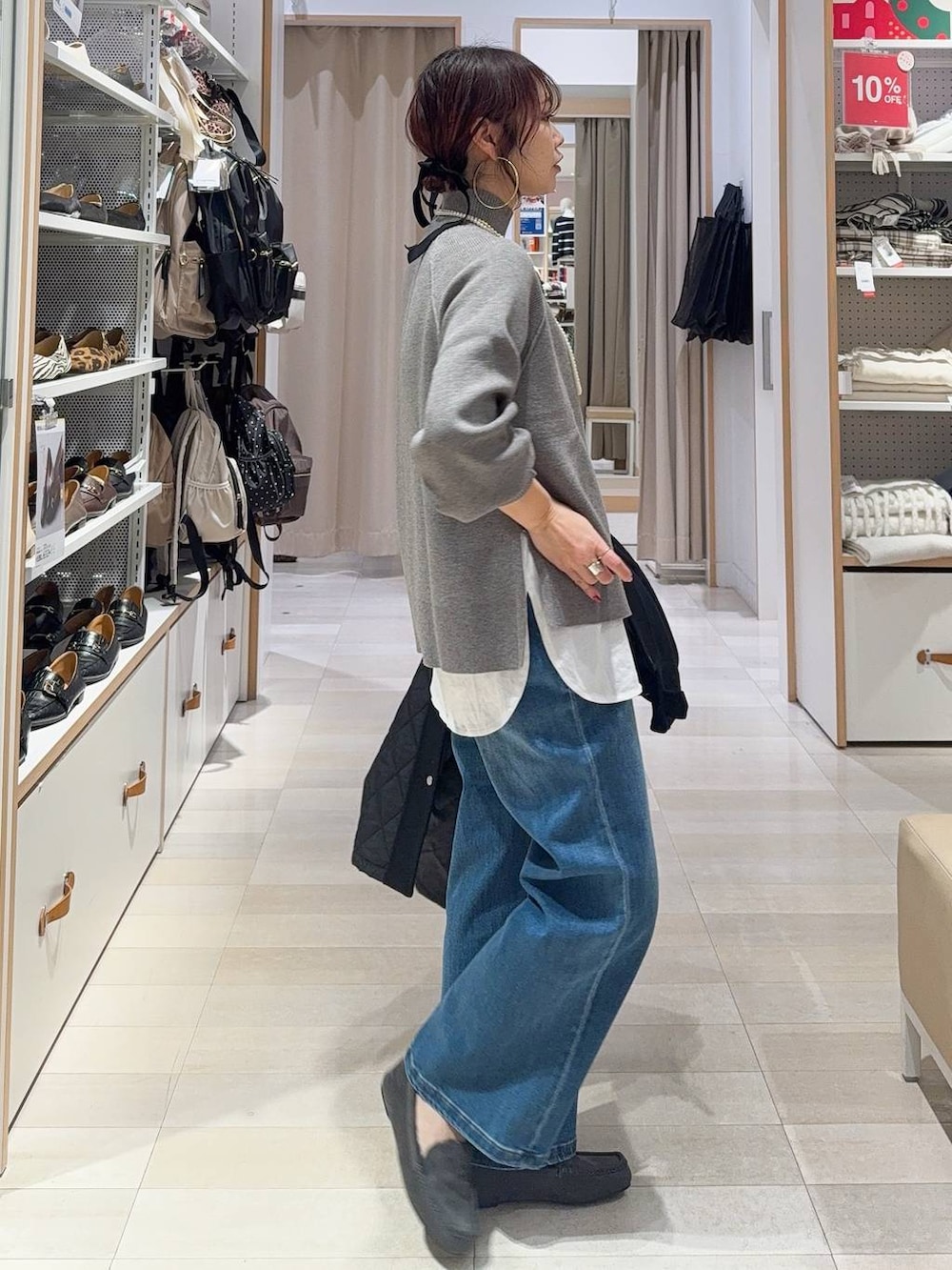 グリーン系のショルダーバッグ、ブラック系のステンカラーコート、ホワイト系のTシャツ/カットソーを着用したレディースの冬コーディネートの6枚目の写真