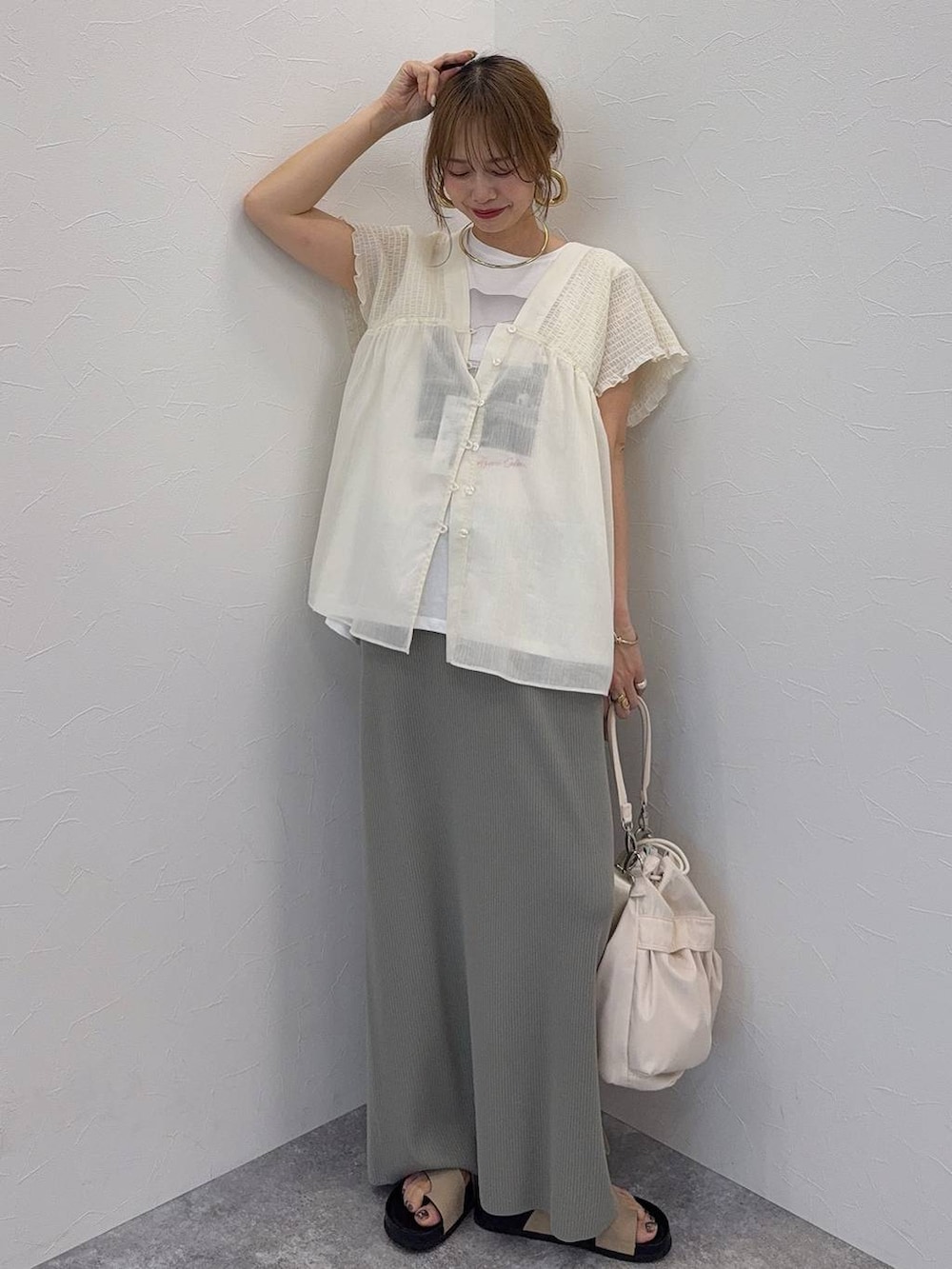 ブルー系のデニムパンツ、ブラウン系のボストンバッグ、レッド系のシャツ/ブラウスを着用したレディースの夏コーディネートの3枚目の写真