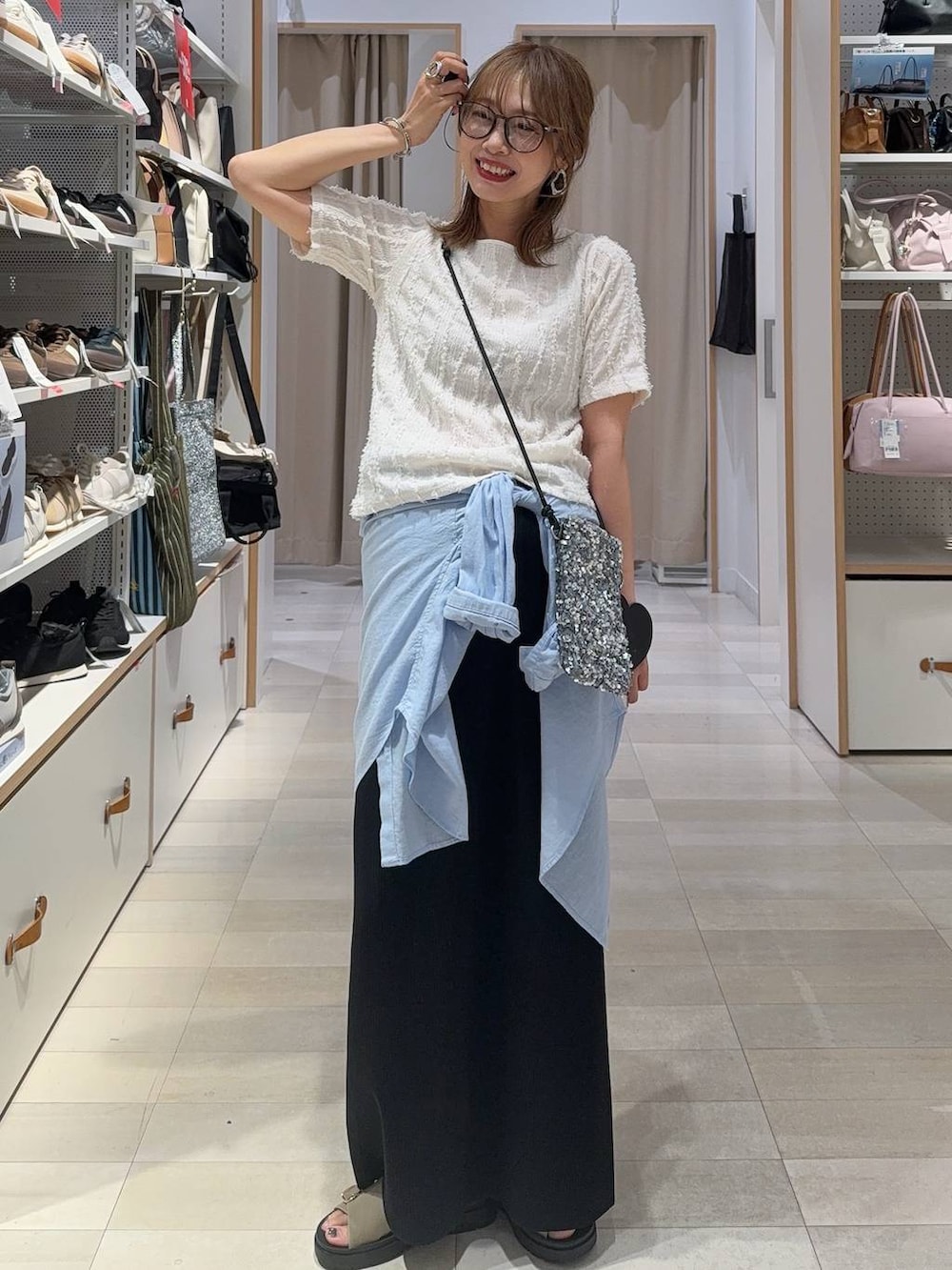 ブラック系のベスト、ホワイト系のTシャツ/カットソー、ブラック系のスカートを着用したレディースの夏コーディネートの2枚目の写真