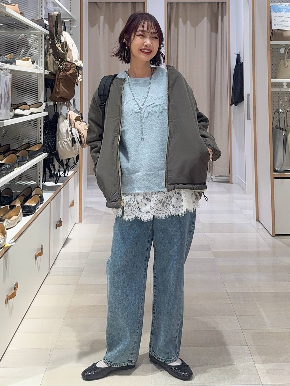 ブラック系のバレエシューズ、グレー系のブルゾン、ブルー系のデニムパンツを着用したレディースの秋コーディネートの2枚目の写真