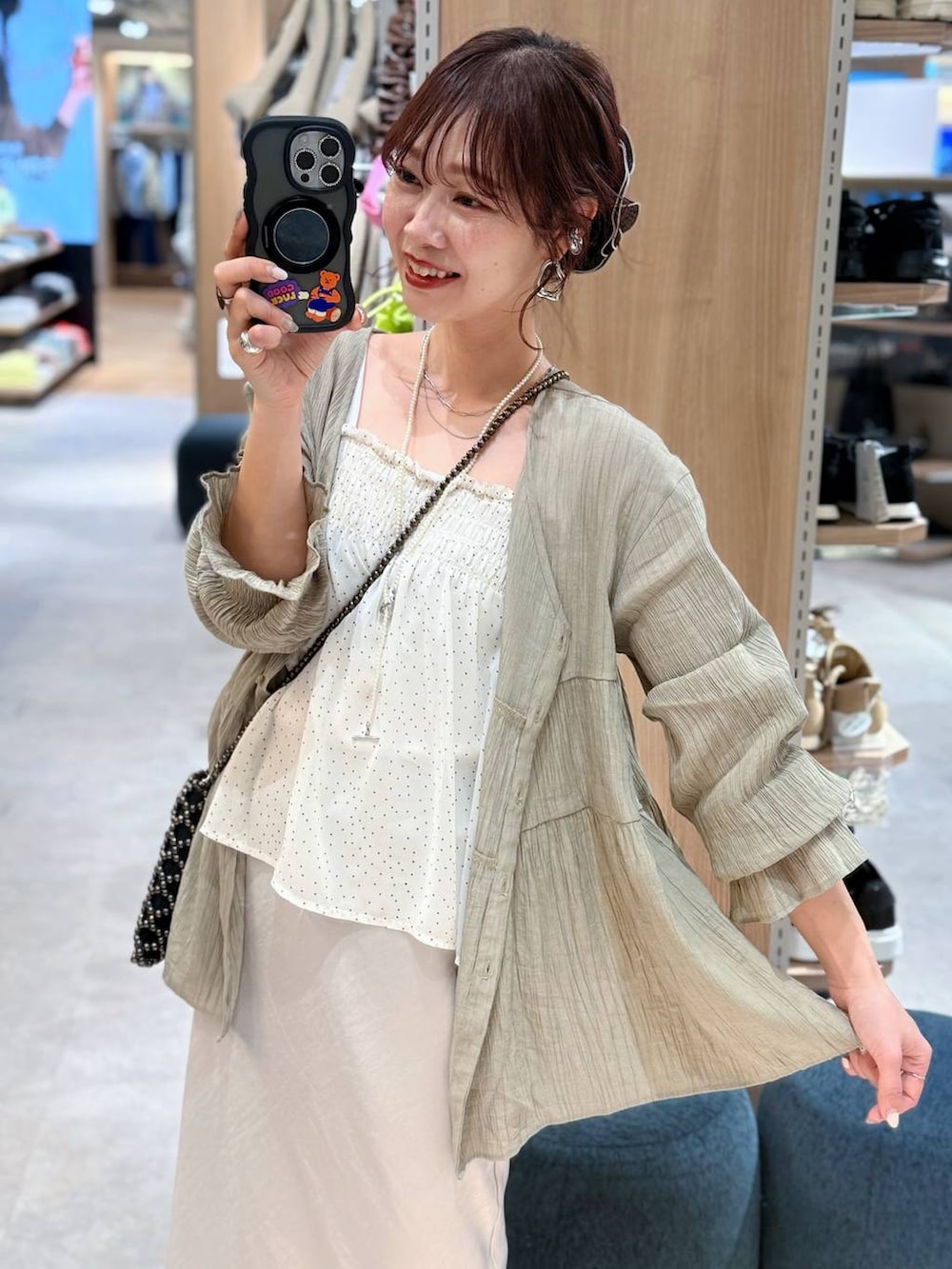 ブラック系のデニムパンツ、ベージュ系のシャツ/ブラウス、ベージュ系のバンダナ/スカーフを着用したレディースの春コーディネートの2枚目の写真