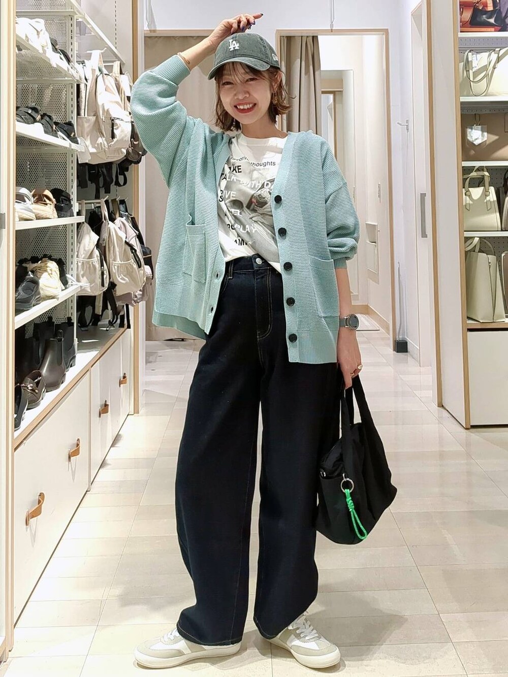 ブラック系のショルダーバッグ、グリーン系のカーディガン/ボレロ、グレー系のスカートを着用したレディースの春コーディネートの3枚目の写真