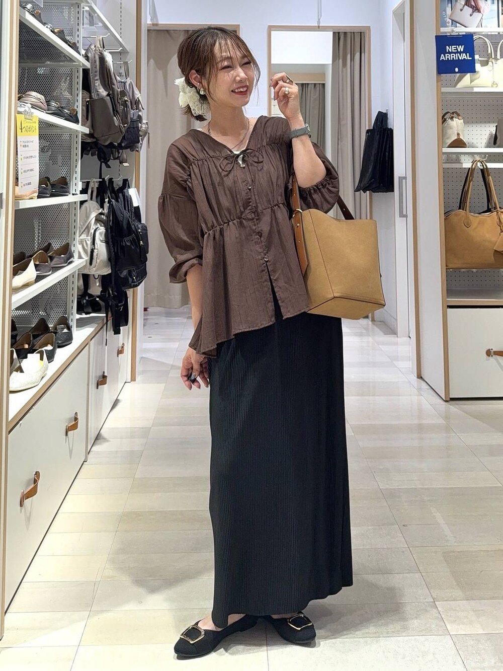 ブルー系のデニムパンツ、ブラック系のボストンバッグ、ブラック系のシャツ/ブラウスを着用したレディースの秋コーディネートの6枚目の写真