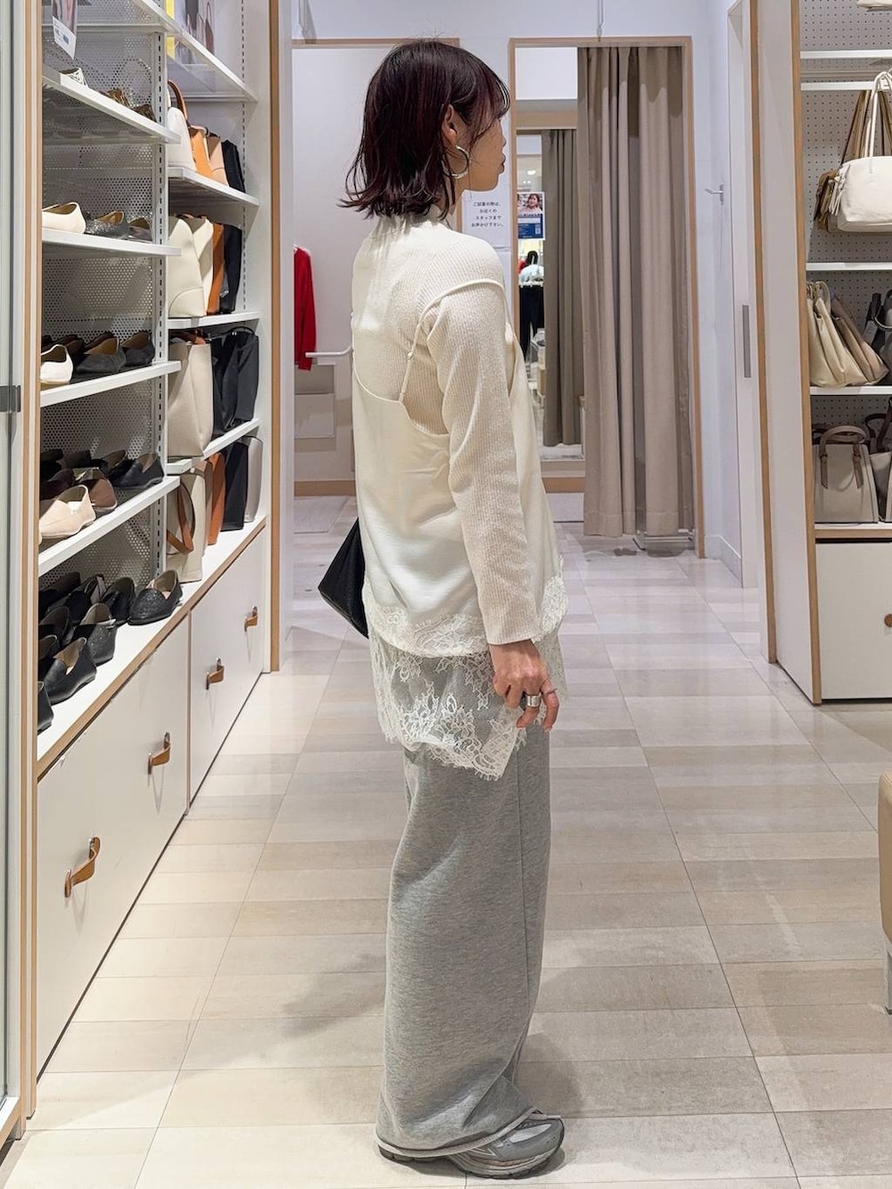 ホワイト系のニット/セーター、グレー系のスウェットパンツを着用したレディースの冬コーディネートの8枚目の写真