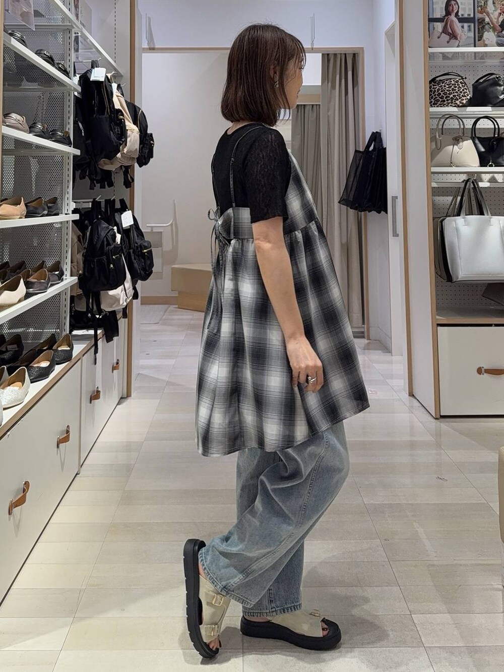 ブルー系のデニムパンツ、ホワイト系のキャミソール、ブラック系のキャミソールを着用したレディースの夏コーディネートの5枚目の写真