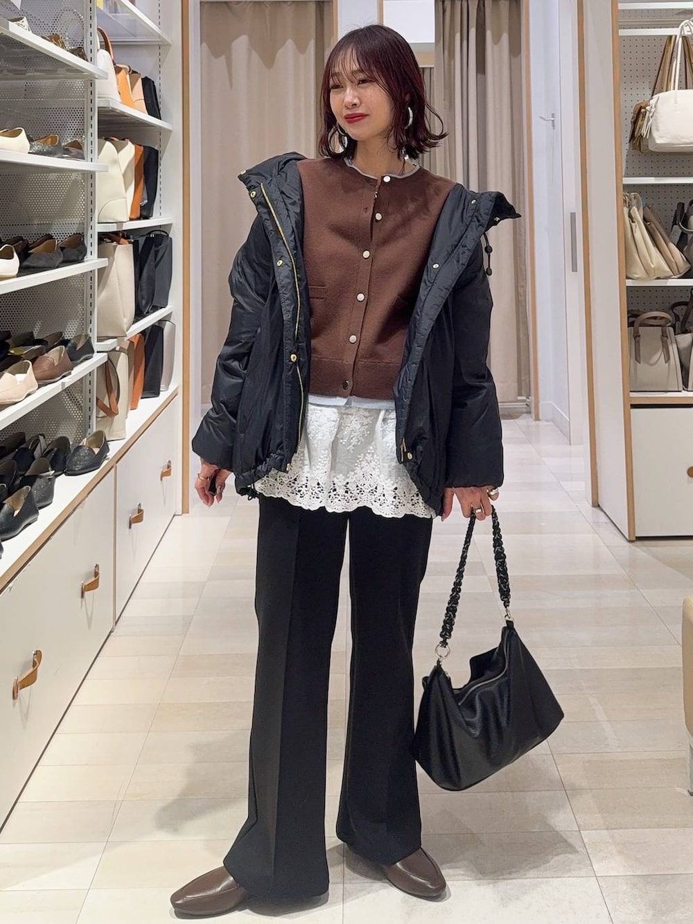 ブルー系のダウンジャケット/コート、ブラウン系のカーディガン/ボレロ、ブラック系のスウェットパンツを着用したレディースの冬コーディネートの2枚目の写真