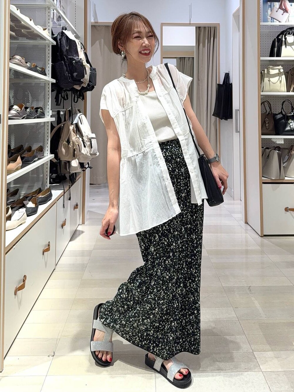 ブルー系のデニムパンツ、ベージュ系のキャミソール、ベージュ系のトートバッグを着用したレディースの夏コーディネートの2枚目の写真