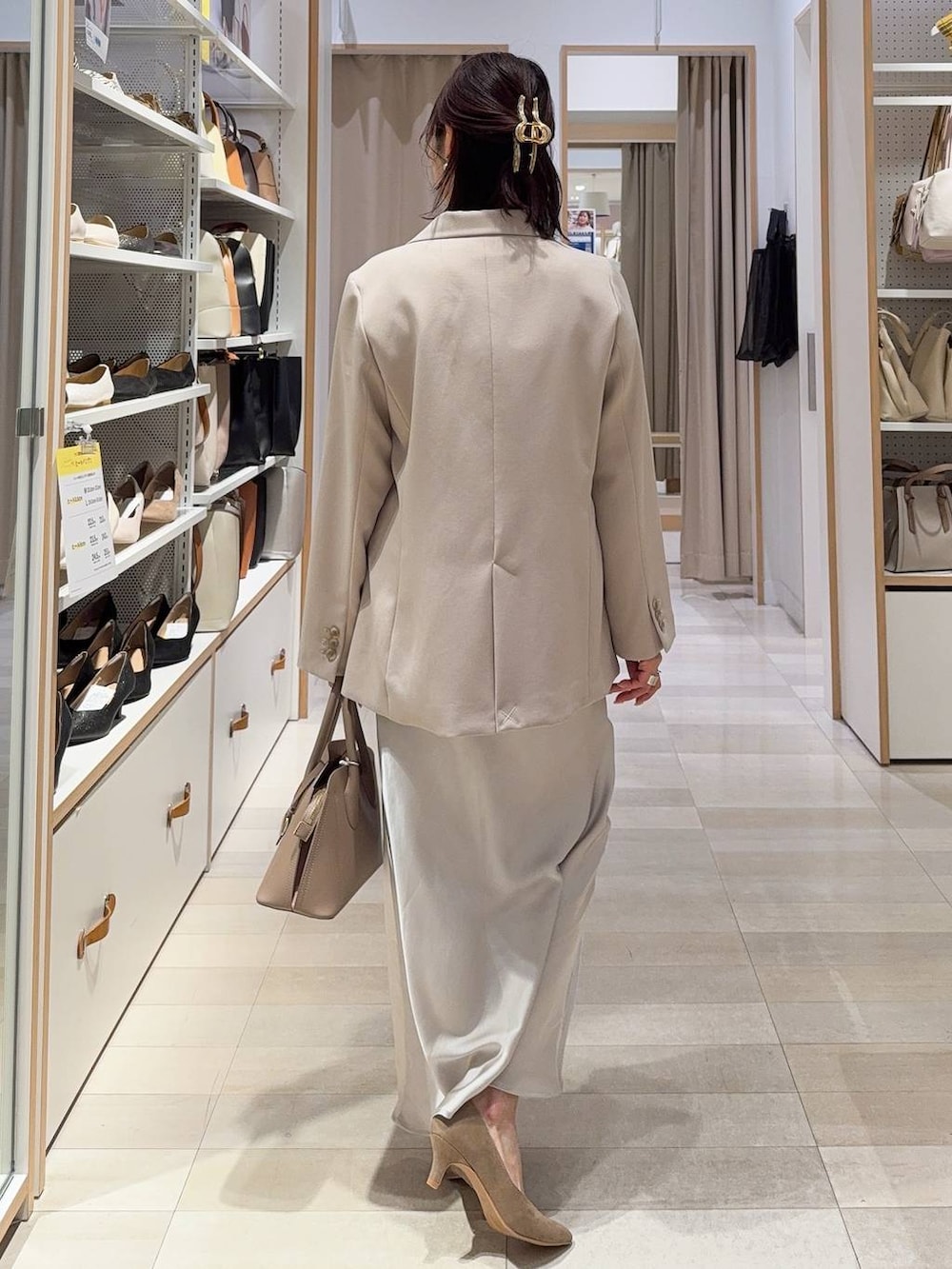 ベージュ系のショルダーバッグ、ベージュ系のパンプス、ホワイト系のキャミソールを着用したレディースの冬コーディネートの6枚目の写真