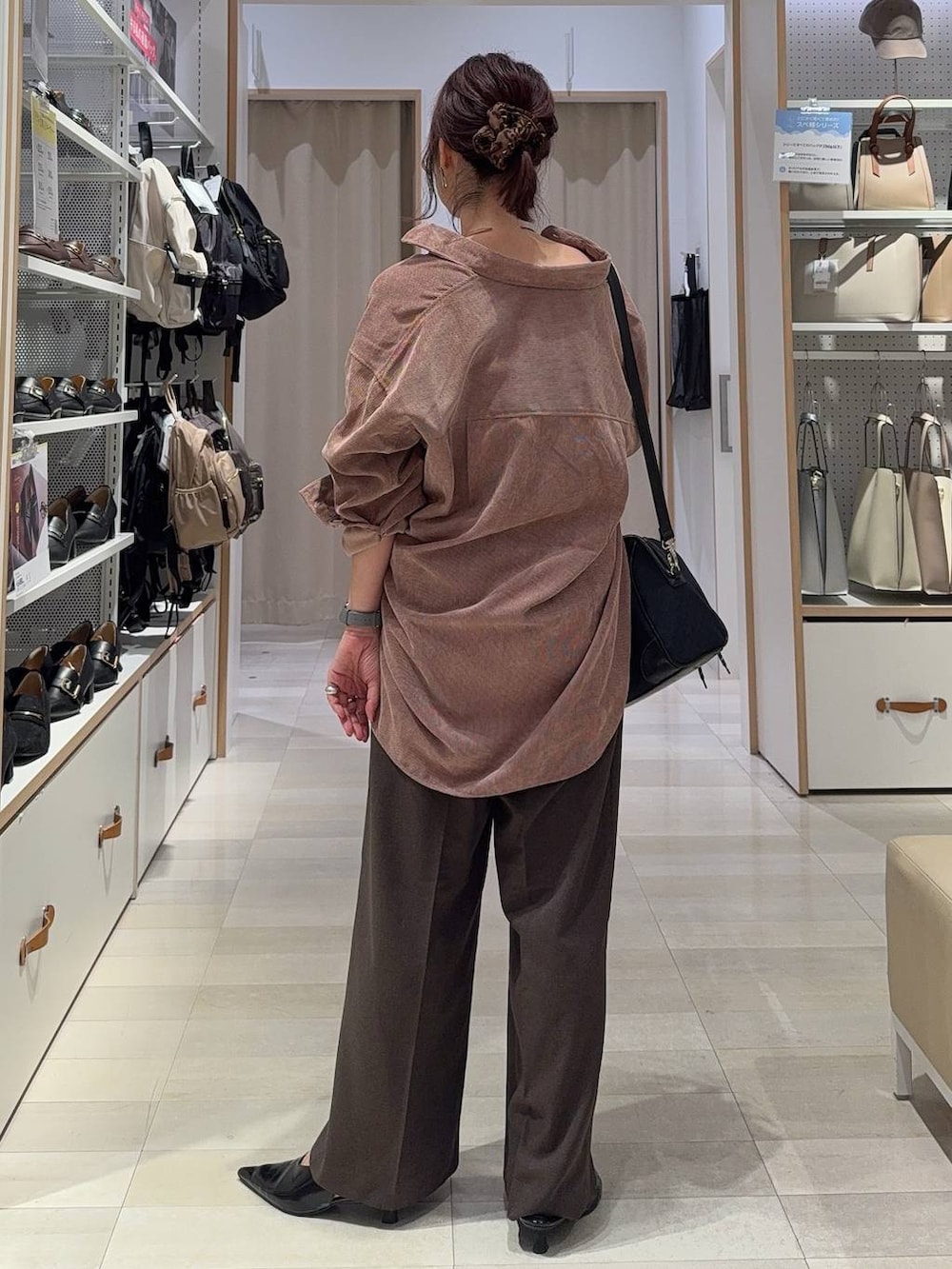 ブラック系のパンプス、ブラウン系のスラックス、ブラック系のボストンバッグを着用したレディースの秋コーディネートの9枚目の写真