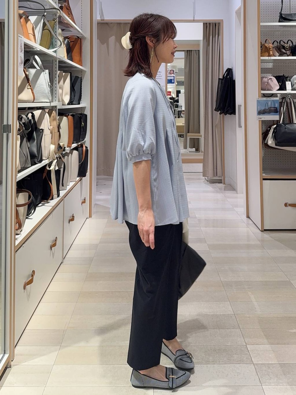 ブラック系のパンプス、ブルー系のスラックス、ホワイト系のカーディガン/ボレロを着用したレディースの春コーディネートの6枚目の写真