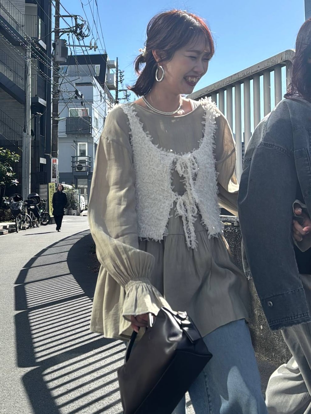 ホワイト系のスカート、グレー系のその他パンツ、ホワイト系のベストを着用したレディースの春コーディネートの4枚目の写真