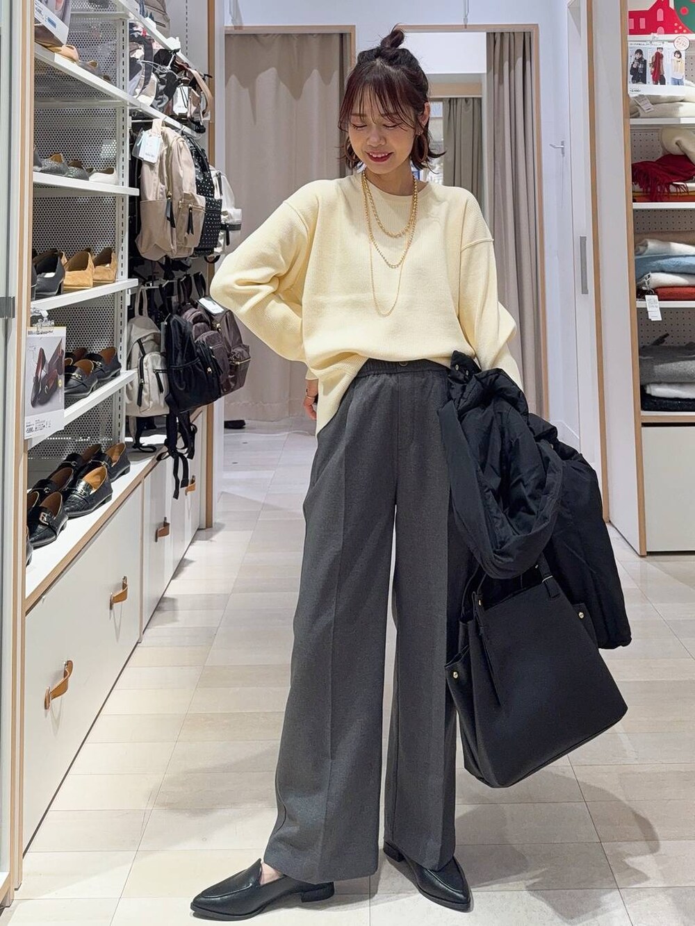 ホワイト系のショルダーバッグ、ブラック系のダウンジャケット/コート、ホワイト系のニット/セーターを着用したレディースの冬コーディネートの3枚目の写真