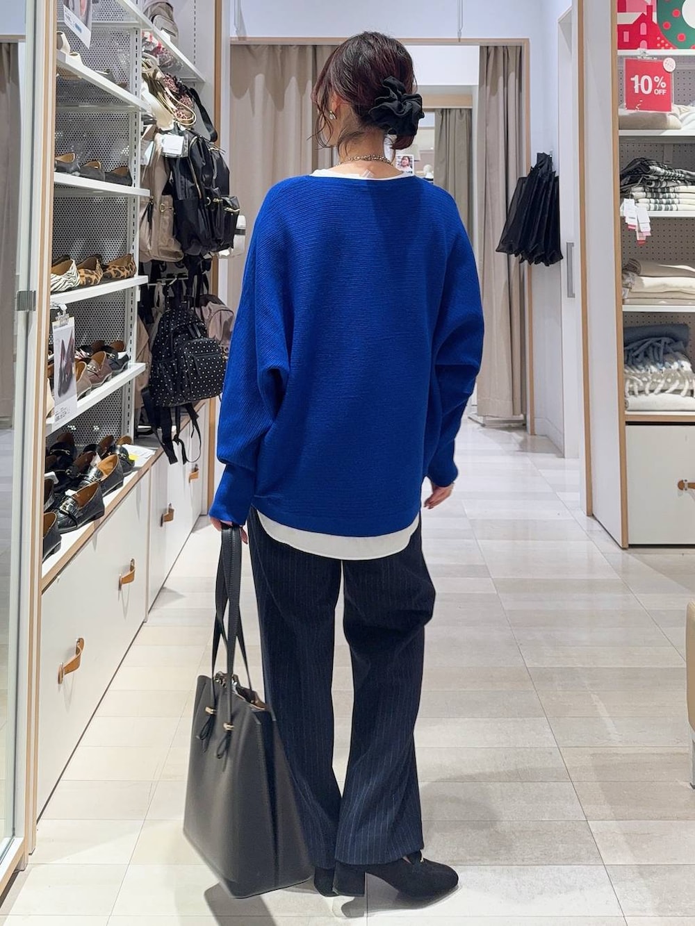 ブラック系のローファー、ホワイト系のTシャツ/カットソー、ブルー系のニット/セーターを着用したレディースの冬コーディネートの4枚目の写真