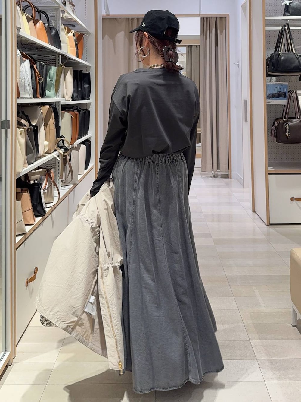 ブラック系のスニーカー、ベージュ系のパーカー、ブラウン系のトートバッグを着用したレディースの春コーディネートの7枚目の写真