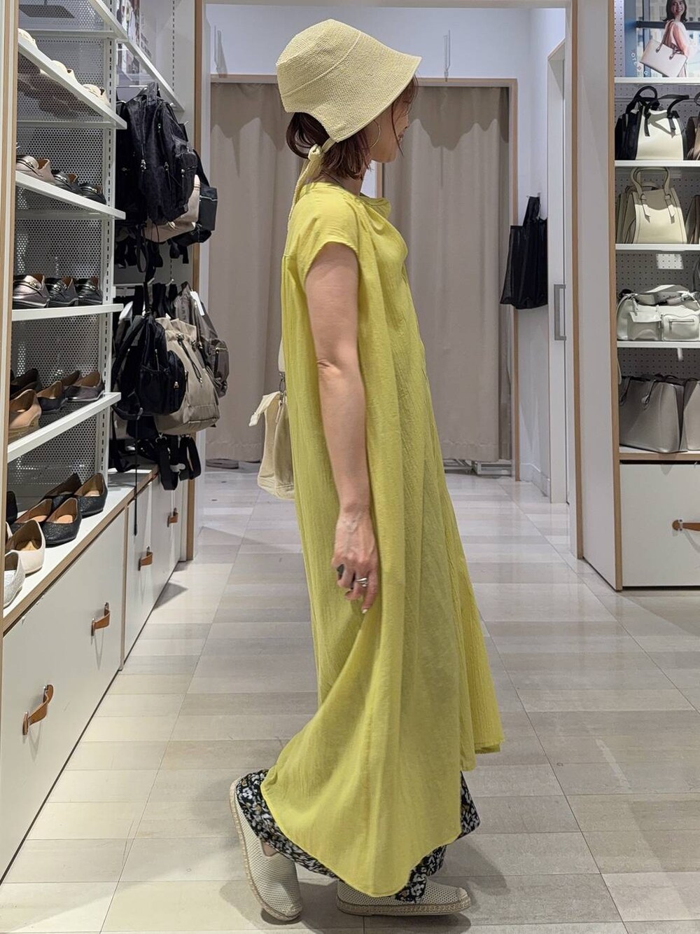 ホワイト系のトートバッグ、ホワイト系のスリッポン、ベージュ系のキャミソールを着用したレディースの夏コーディネートの3枚目の写真