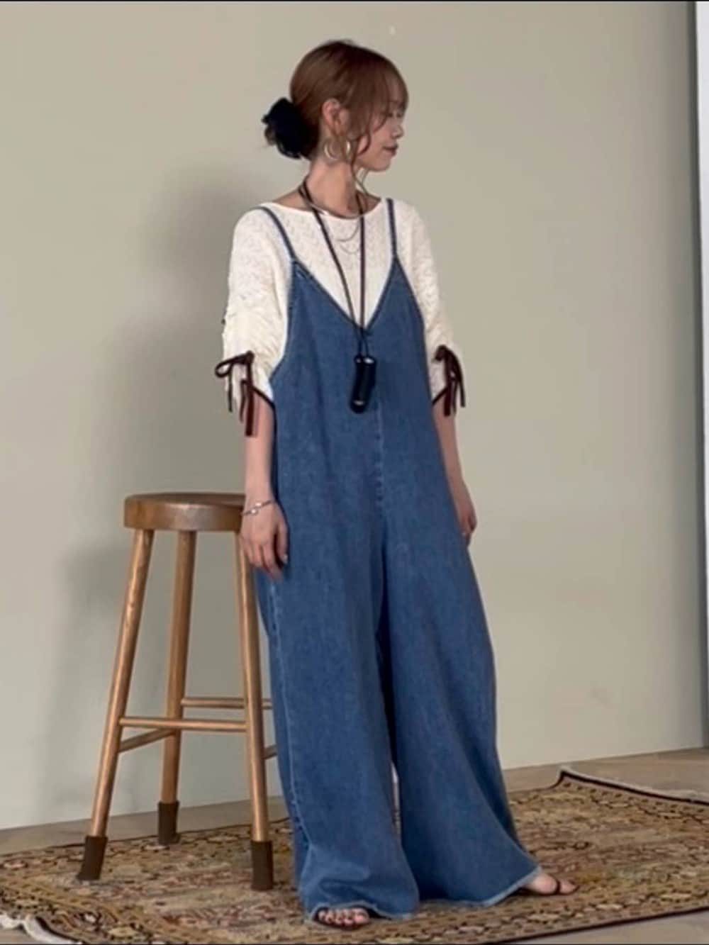 ブラウン系のスカート、シルバー系のネックレス、ブラック系のその他小物を着用したレディースの夏コーディネートの2枚目の写真