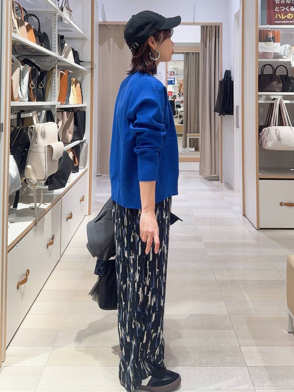 ブラック系のスニーカー、ブラック系のボストンバッグ、ブルー系のニット/セーターを着用したレディースの冬コーディネートの6枚目の写真