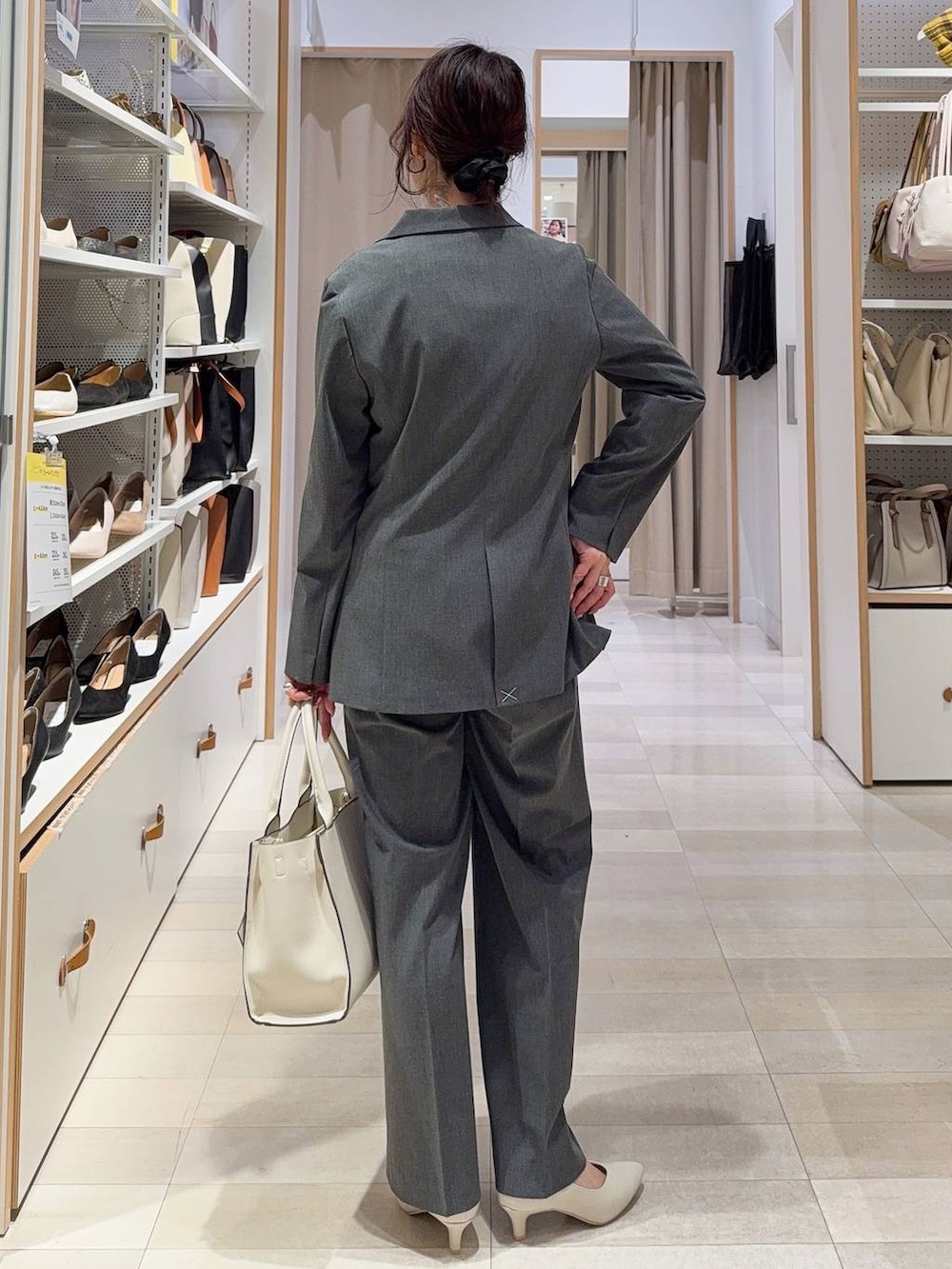 ブラック系のパンプス、グレー系のスラックス、グレー系のテーラードジャケットを着用したレディースの冬コーディネートの5枚目の写真