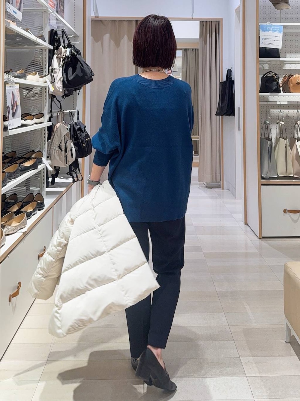 ブラック系のローファー、ホワイト系のショルダーバッグ、ベージュ系のダウンジャケット/コートを着用したレディースの秋コーディネートの7枚目の写真