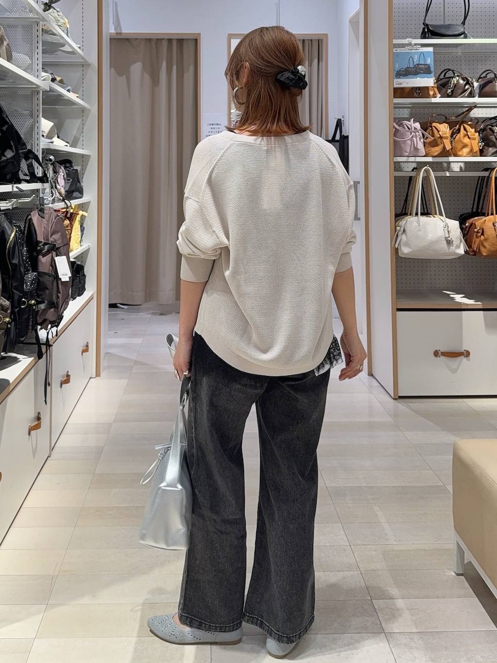 シルバー系のショルダーバッグ、ブラック系のデニムパンツ、ホワイト系のカーディガン/ボレロを着用したレディースの夏コーディネートの5枚目の写真