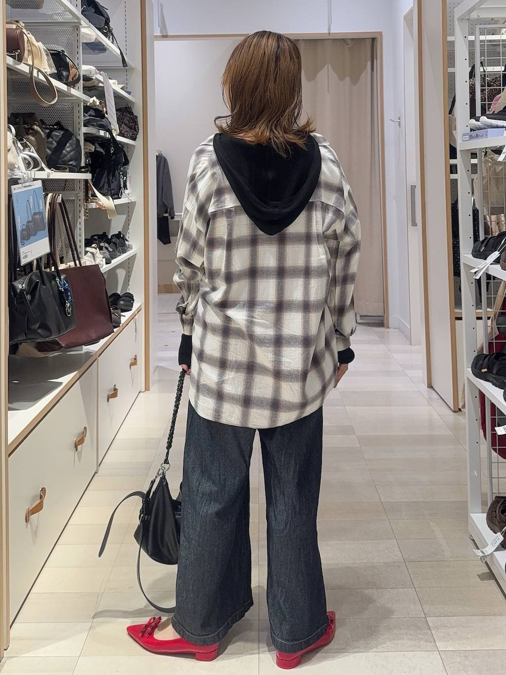 ブラック系のパーカー、ホワイト系のシャツ/ブラウス、ブルー系のデニムパンツを着用したレディースの秋コーディネートの9枚目の写真