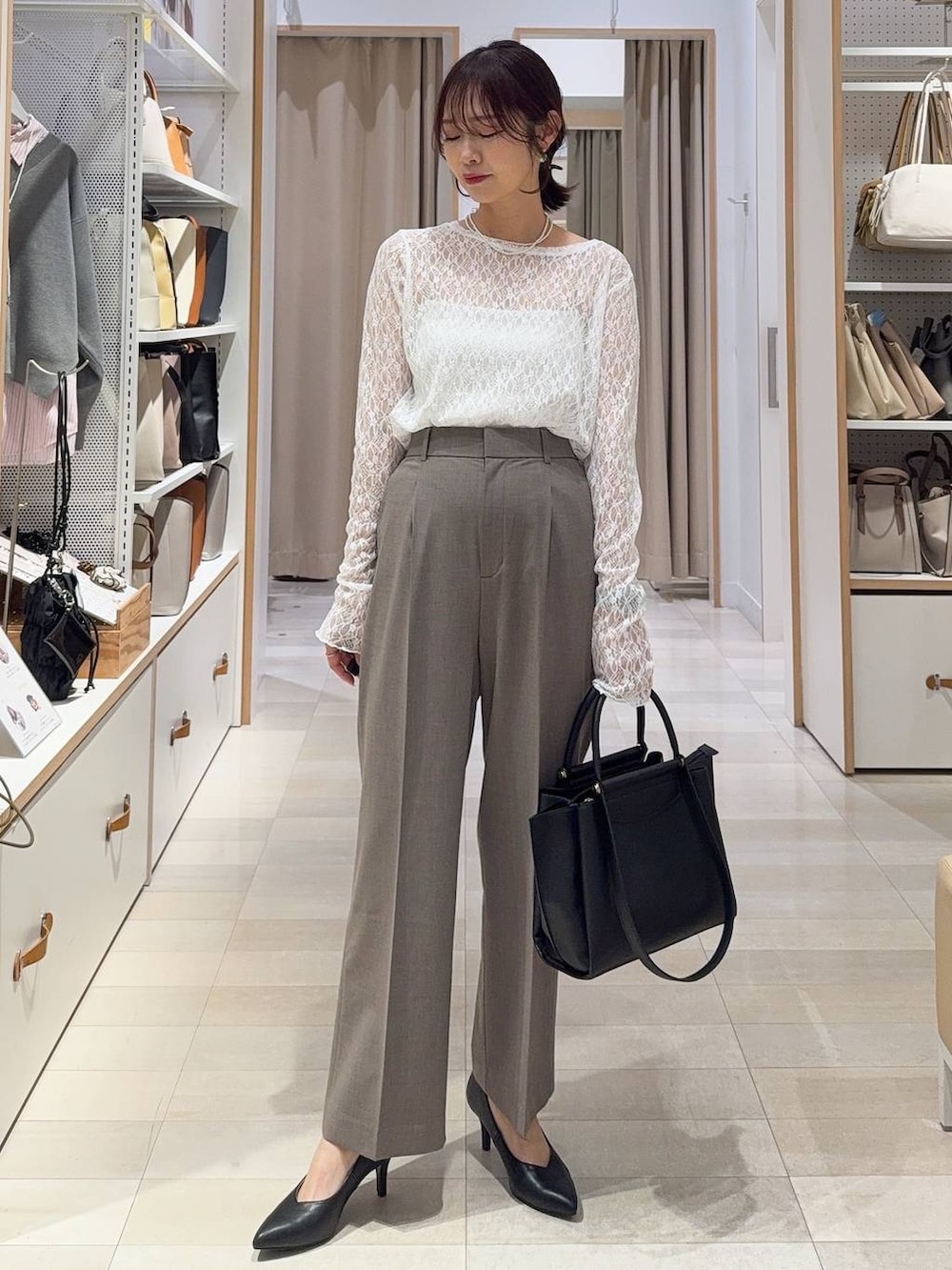 ホワイト系のキャミソール、ホワイト系のTシャツ/カットソー、ブラウン系のスラックスを着用したレディースの冬コーディネートの2枚目の写真