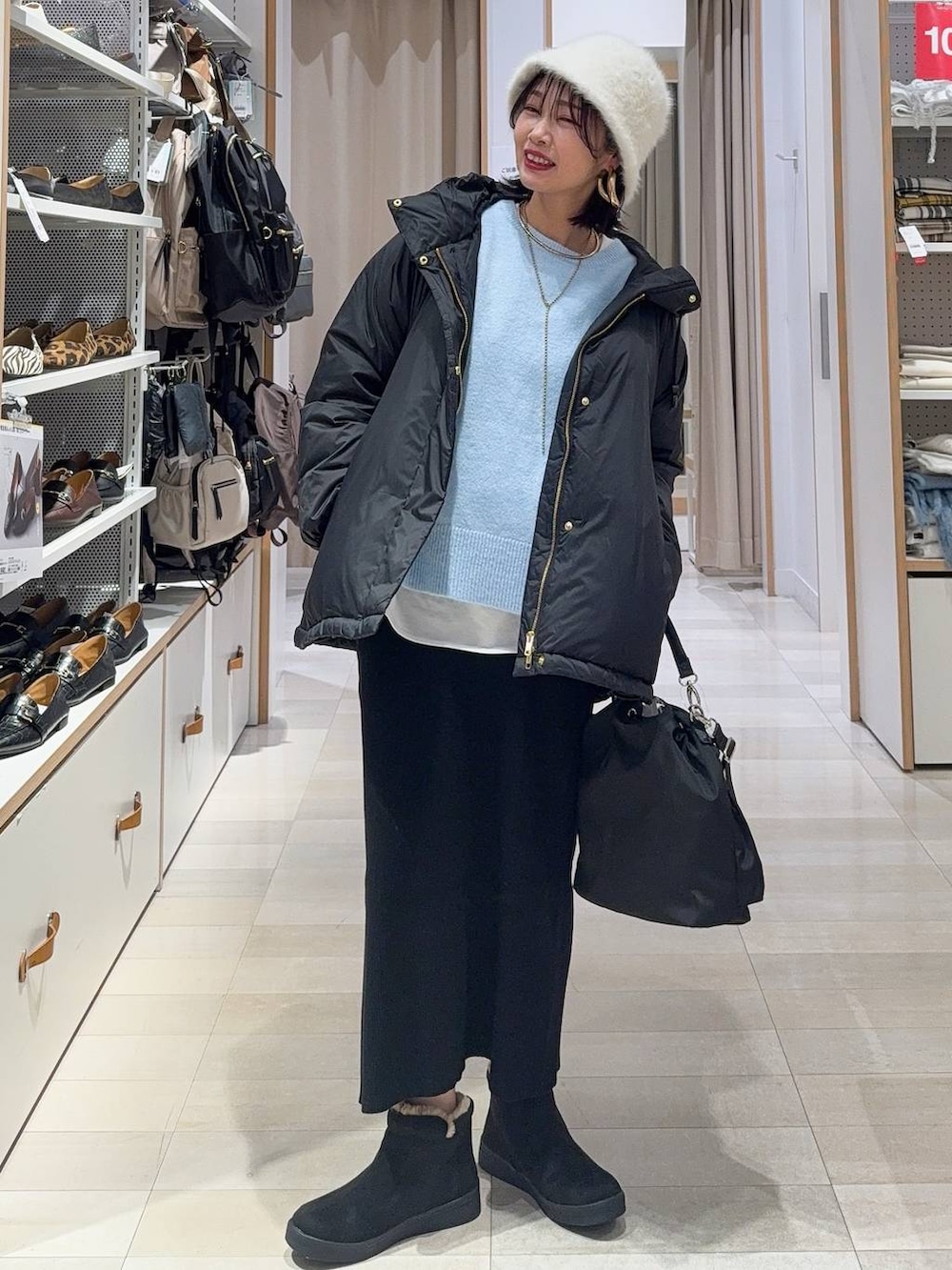 ブラック系のショルダーバッグ、ブラック系のダウンジャケット/コート、ブルー系のニット/セーターを着用したレディースの冬コーディネートの2枚目の写真