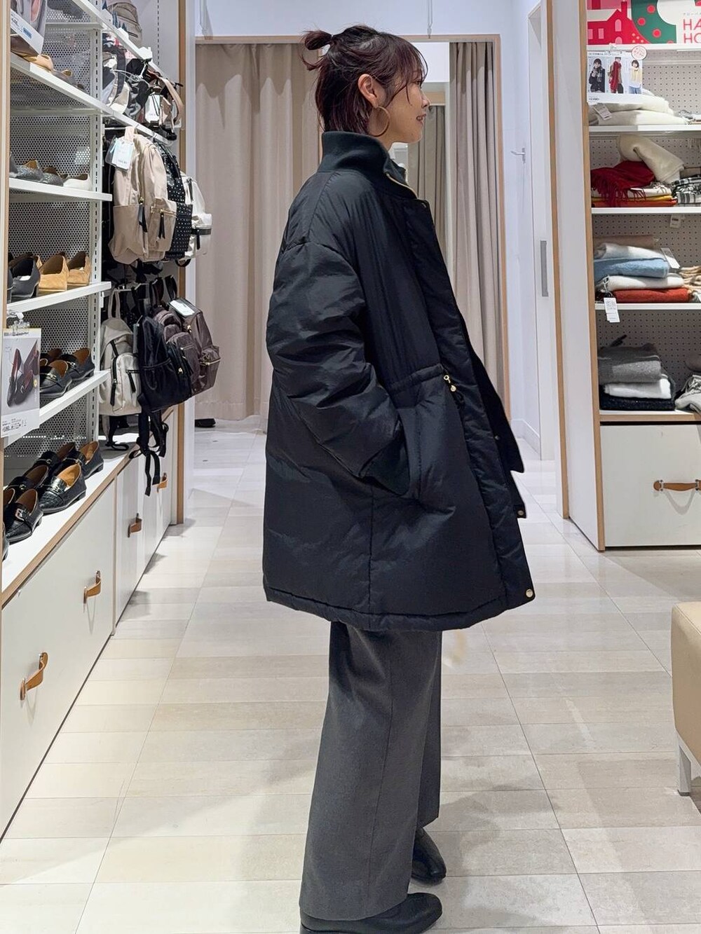 ホワイト系のショルダーバッグ、ブラック系のダウンジャケット/コート、ホワイト系のニット/セーターを着用したレディースの冬コーディネートの4枚目の写真