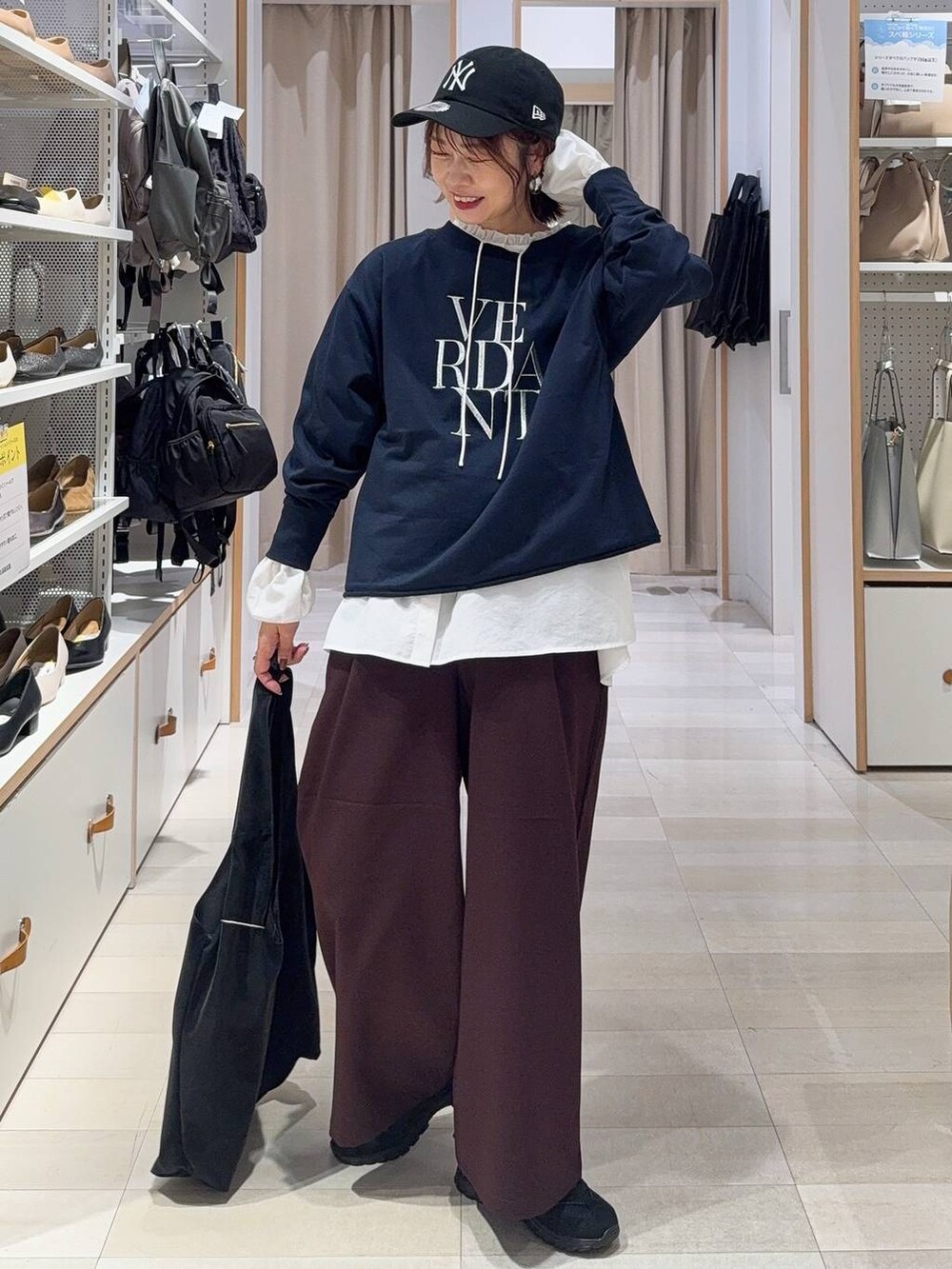 ブラック系のバックパック/リュック、ブラック系のスニーカー、グレー系のスカートを着用したレディースの秋コーディネートの2枚目の写真