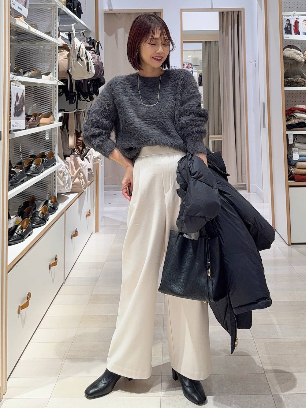 ブラック系のダウンジャケット/コート、ブラック系のトートバッグ、グレー系のその他パンツを着用したレディースの冬コーディネートの2枚目の写真