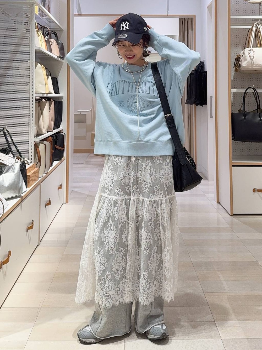 ブルー系のチェスターコート、グレー系のワンピース、ブルー系のスウェットを着用したレディースの冬コーディネートの3枚目の写真