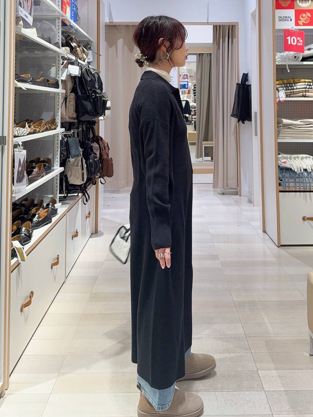 グリーン系のカーディガン/ボレロ、ホワイト系のボストンバッグ、ブラック系のワンピースを着用したレディースの冬コーディネートの6枚目の写真