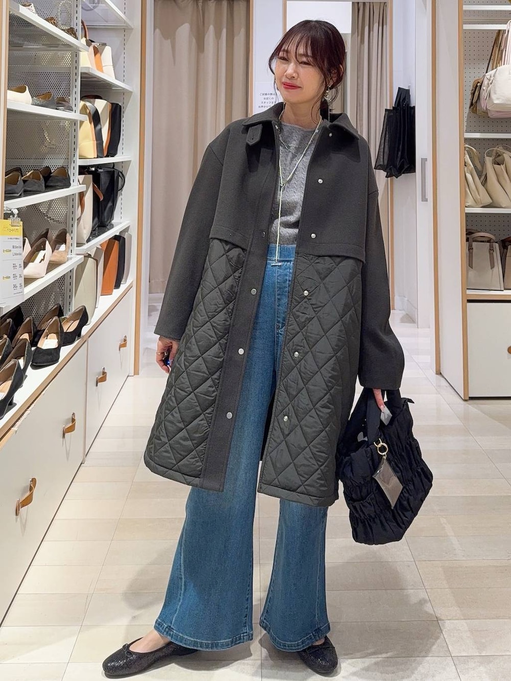 ブラック系のバレエシューズ、ブラウン系のステンカラーコート、ブルー系のデニムパンツを着用したレディースの冬コーディネートの2枚目の写真