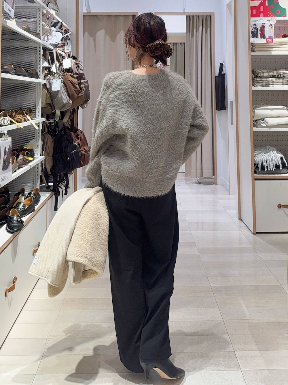 ブラック系のその他パンツ、ブラック系のハンドバッグ、ホワイト系のノーカラージャケットを着用したレディースの冬コーディネートの6枚目の写真