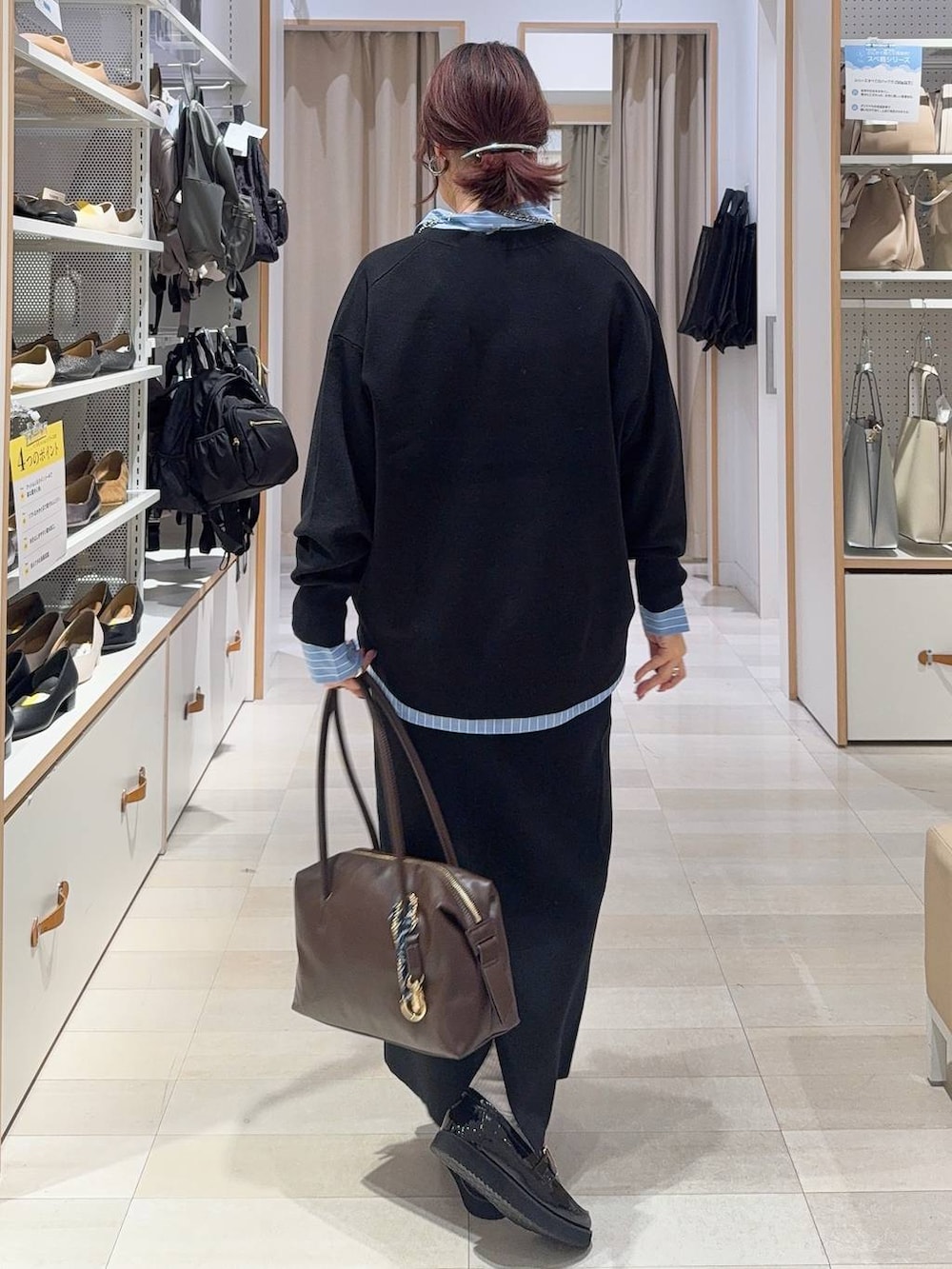 ブラック系のローファー、ブラウン系のボストンバッグ、ブラック系のスウェットを着用したレディースの秋コーディネートの5枚目の写真