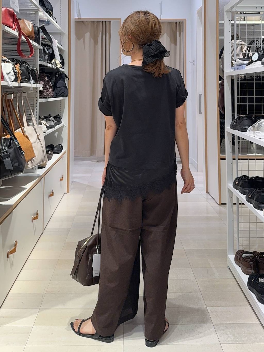 ブラウン系のボストンバッグ、ブラウン系のその他パンツ、ブラック系のTシャツ/カットソーを着用したレディースの夏コーディネートの5枚目の写真