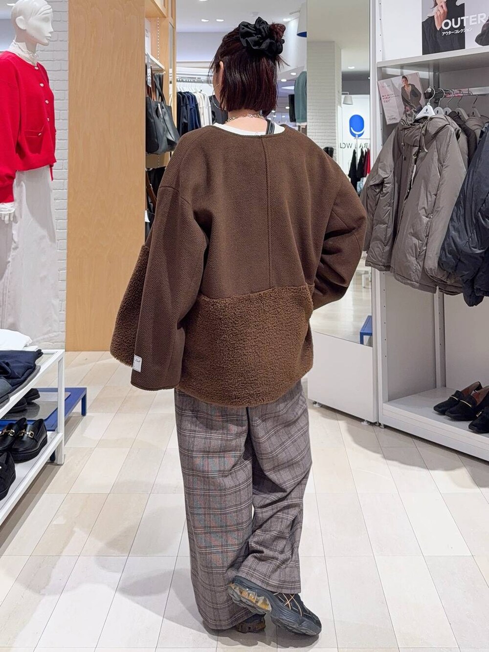 ブラック系のチェスターコート、ブラック系のショルダーバッグ、ホワイト系のTシャツ/カットソーを着用したレディースの秋コーディネートの7枚目の写真