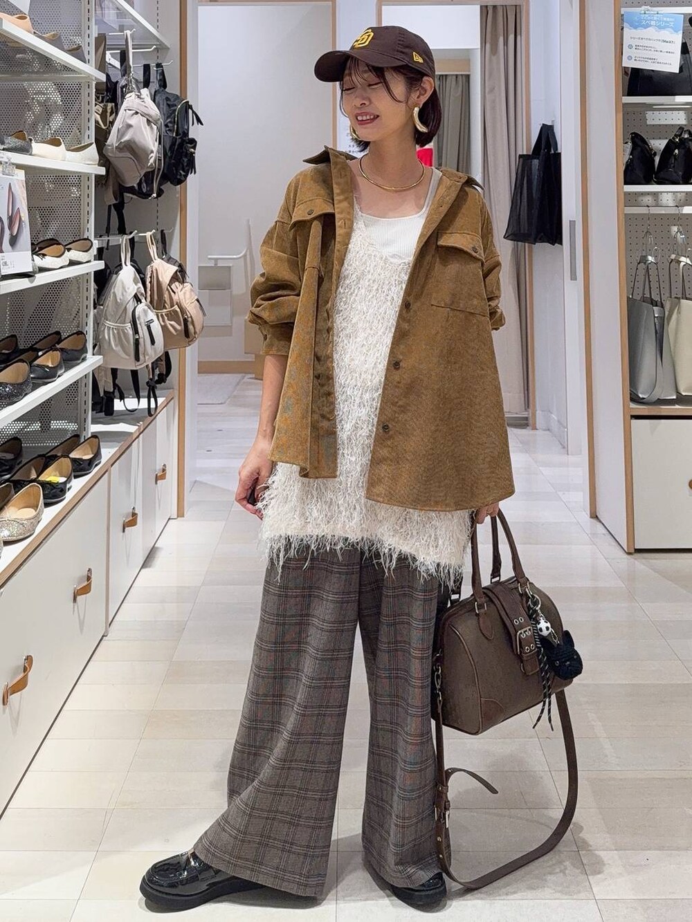 ブラック系のローファー、グリーン系のボストンバッグ、イエロー系のシャツ/ブラウスを着用したレディースの秋コーディネートの3枚目の写真