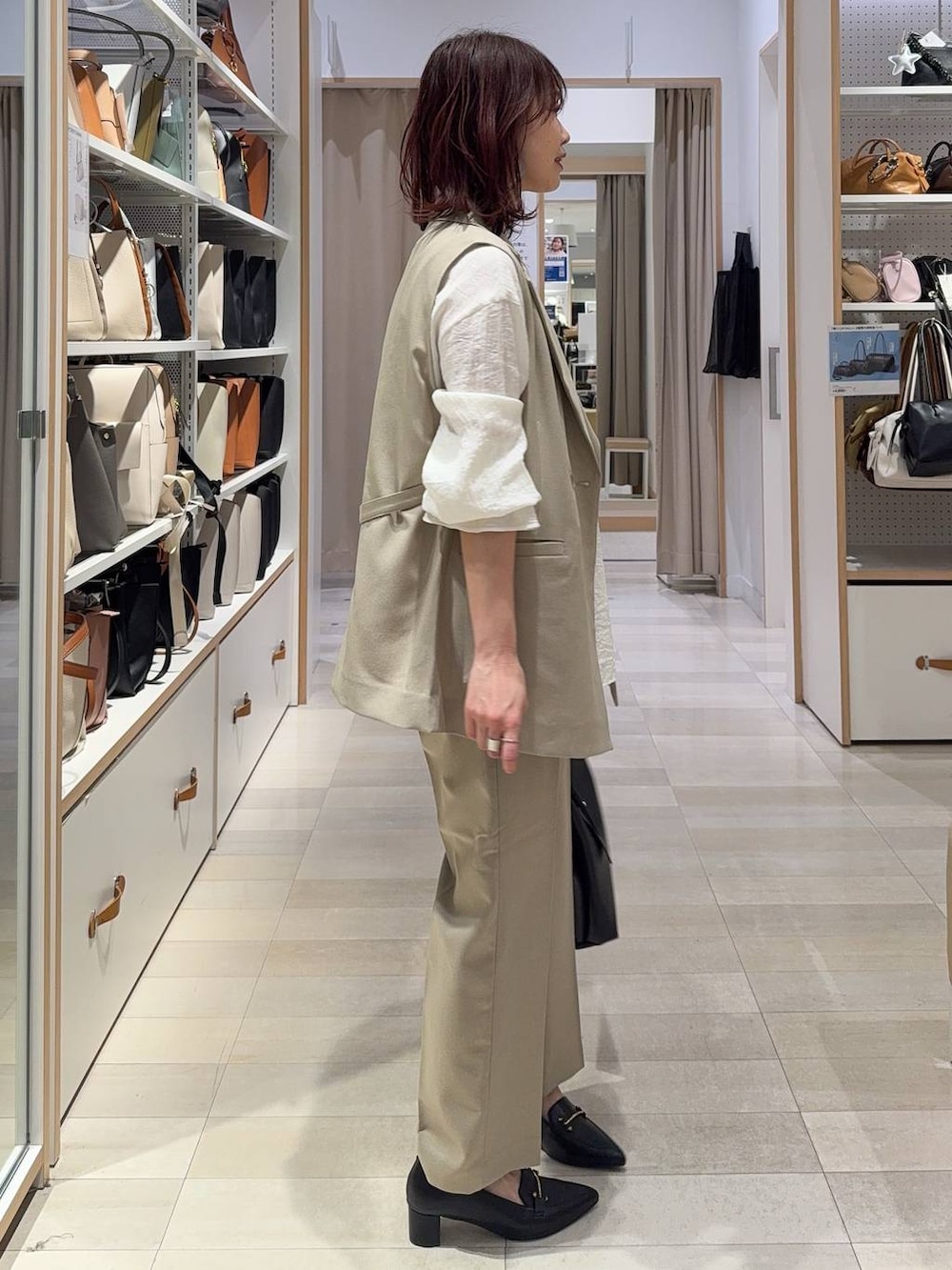 ベージュ系のその他パンツ、ベージュ系のベスト、ブラック系のハンドバッグを着用したレディースの春コーディネートの3枚目の写真