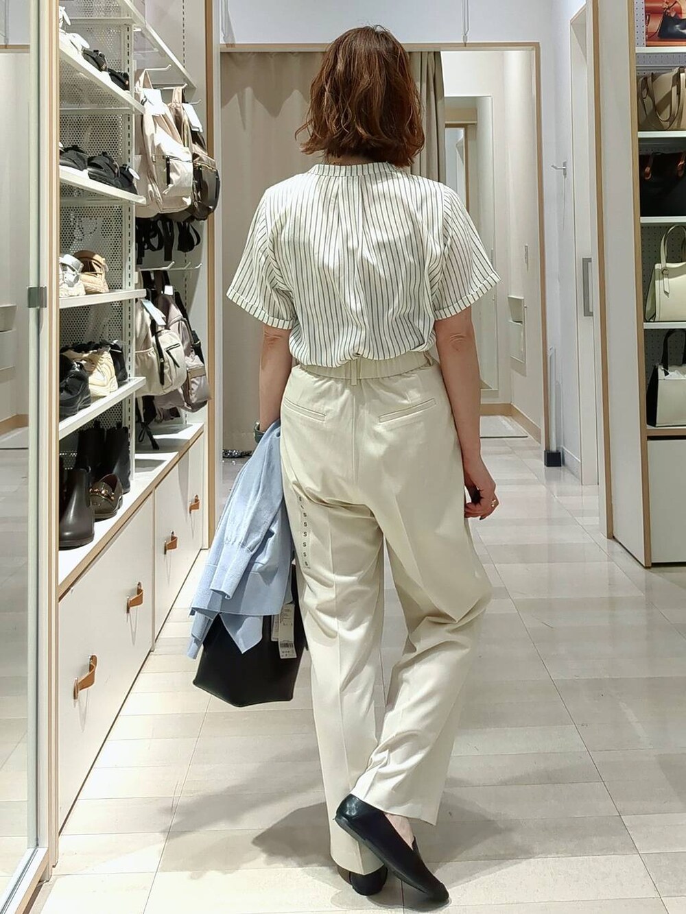 ホワイト系のその他パンツ、ブラック系のその他シューズ、ブラック系のショルダーバッグを着用したレディースの春コーディネートの6枚目の写真