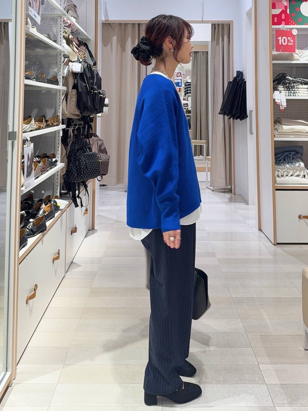 ブラック系のローファー、ホワイト系のTシャツ/カットソー、ブルー系のニット/セーターを着用したレディースの冬コーディネートの3枚目の写真