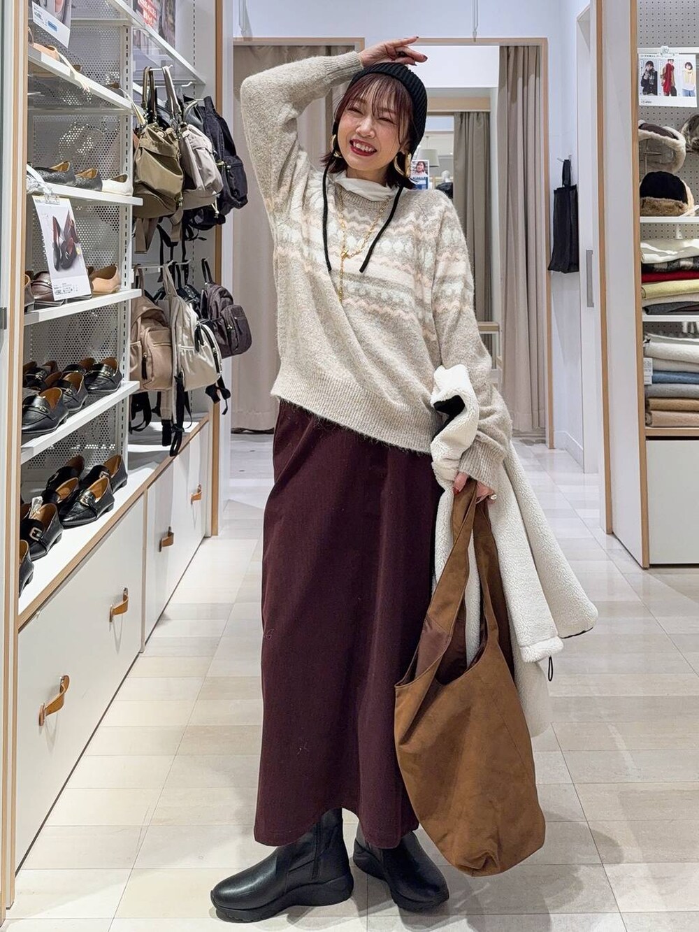 ホワイト系のブルゾン、レッド系のスカート、ベージュ系のトートバッグを着用したレディースの秋コーディネートの3枚目の写真