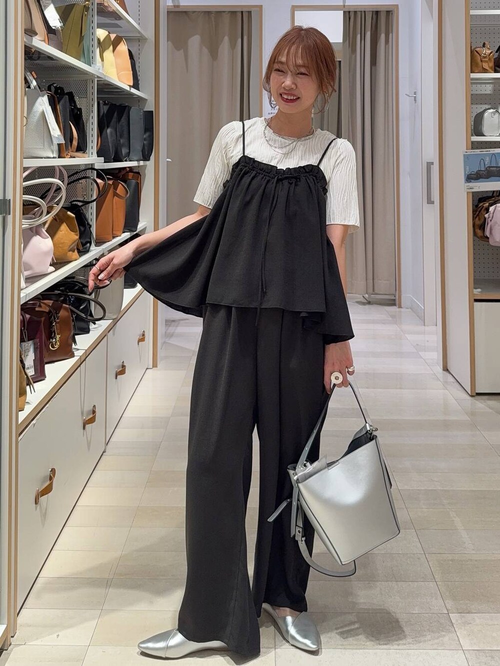 シルバー系のショルダーバッグ、シルバー系のパンプス、ホワイト系のTシャツ/カットソーを着用したレディースの春コーディネートの2枚目の写真